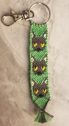 A keychain with 3 gray cat faces on neon green background