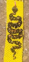 a bright yellow bracelet with a ball python woven into it