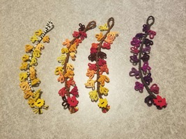 4 bracelts that look like a branch with leaves coming out the sides in a variety of autumn colors