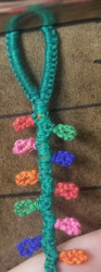 A photo of an unfinished bracelet that is woven to look like colorful holiday lights