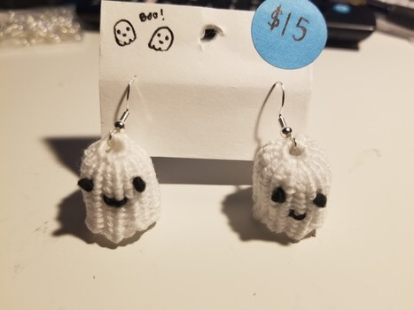 A pair of cute smiling white ghost earrings with silver findings.